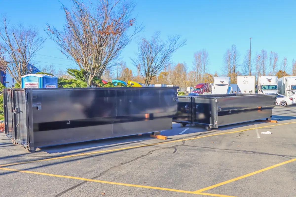 Professional dumpster rental service with roll-off container on residential driveway in East Goshen